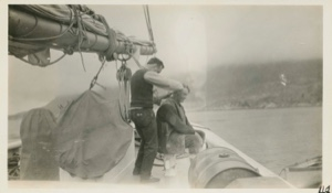 Image of On board the Bowdoin crew members - Bill Boogar cutting Weed's hair
